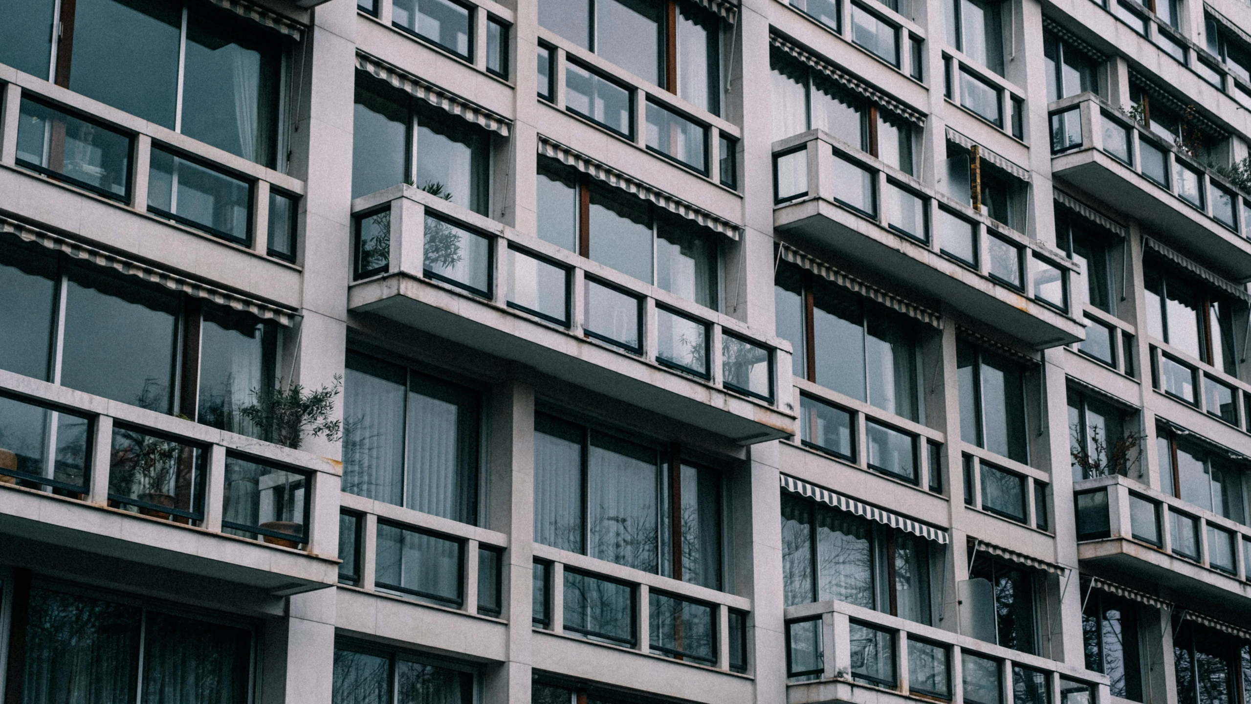 a very tall building with lots of windows, by Emma Andijewska, unsplash, brutalism, crenellated balconies, 1980s photo, awnings, neoclassical style