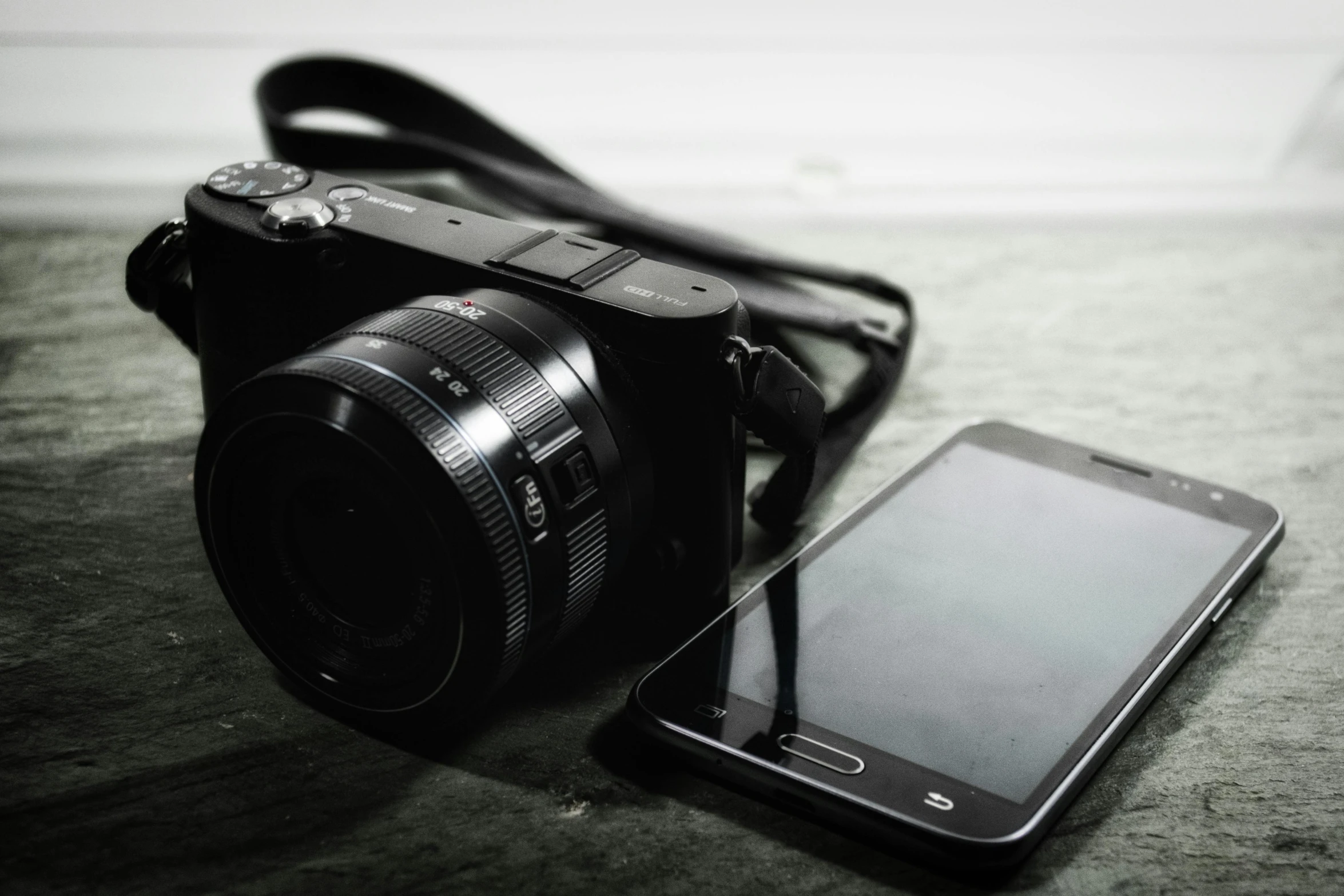 a camera and a cell phone on a table, a picture, sony a7, device, product shot, ((sharp focus))