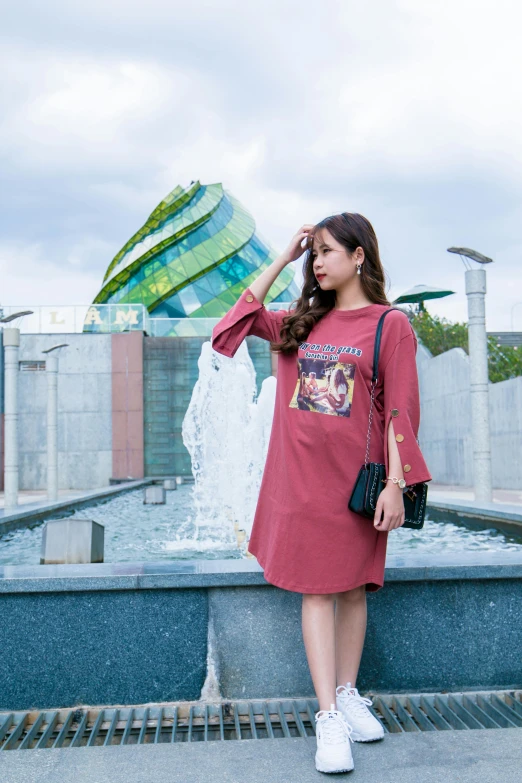 a woman standing in front of a fountain, a picture, by Cherryl Fountain, jpop clothing, maroon, japanese collection product, street photo