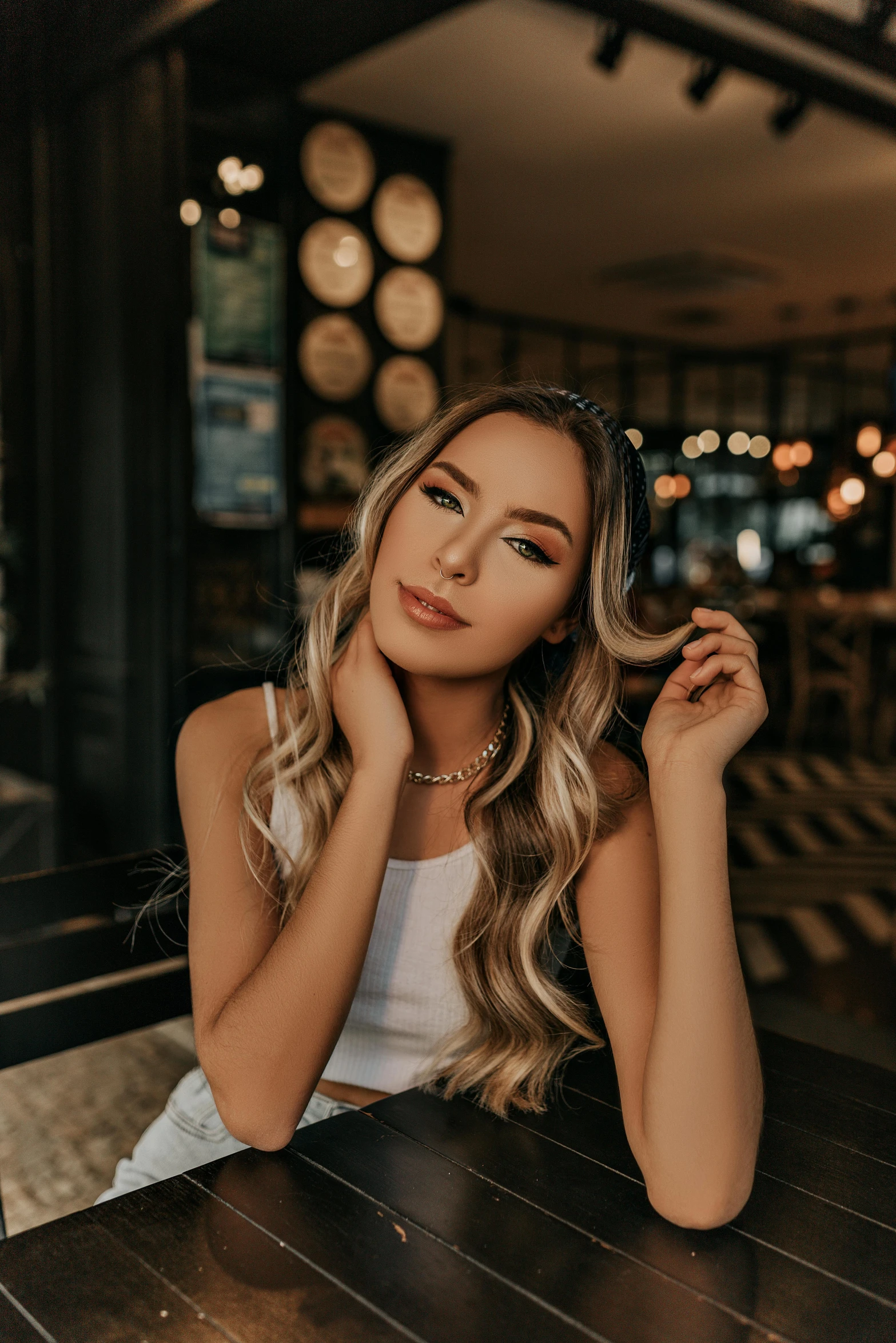 a woman sitting at a table in a restaurant, a portrait, by Julia Pishtar, trending on pexels, hurufiyya, long wavy blonde hair, madison beer girl portrait, 5 0 0 px models, sitting at the bar