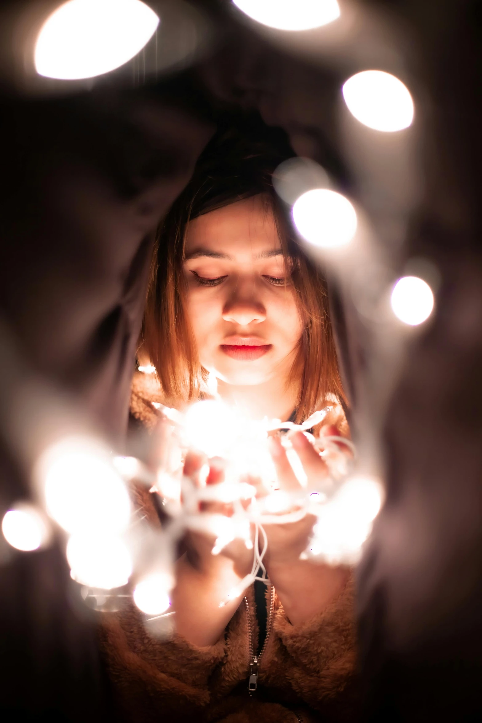 a woman holding a sparkler in front of her face, pexels contest winner, light and space, christmas lights, contemplation, emerging from her lamp, gif