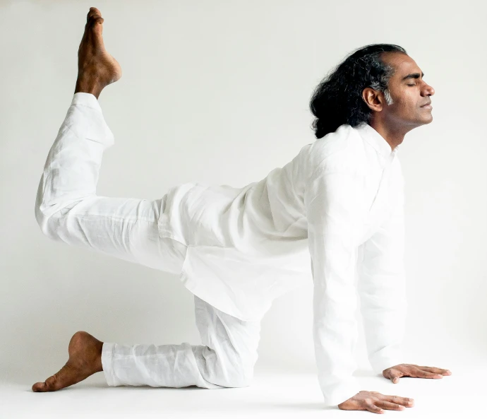 a man in a white shirt doing a yoga pose, by Carey Morris, nivanh chanthara, wearing white pajamas, profile image, posed