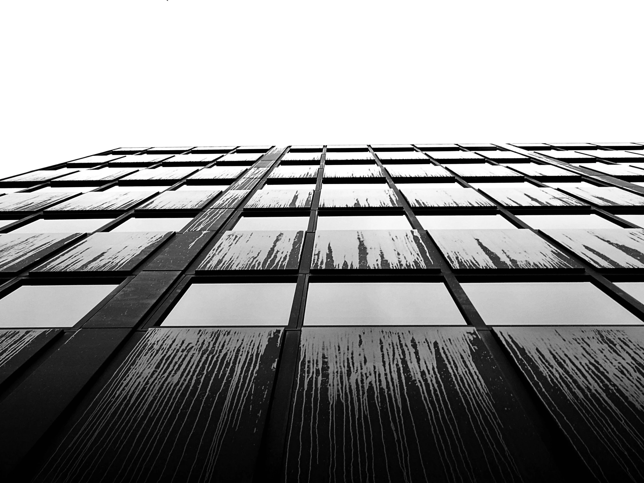 a black and white photo of a tall building, minimalism, glass rain, 4k greyscale hd photography, front - facing perspective, drips