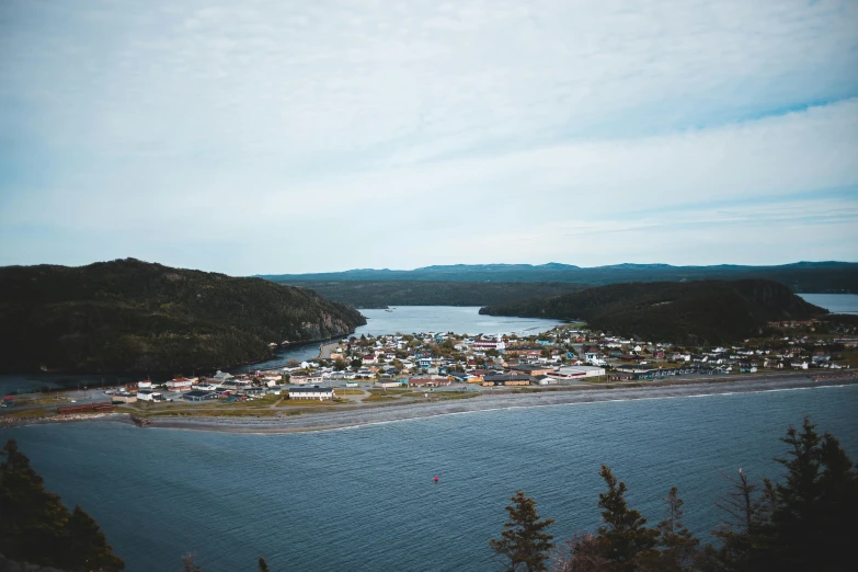 a large body of water sitting next to a lush green hillside, by Jessie Algie, pexels contest winner, happening, fishing town, francois legault, viewed from bellow, an island made of caviar