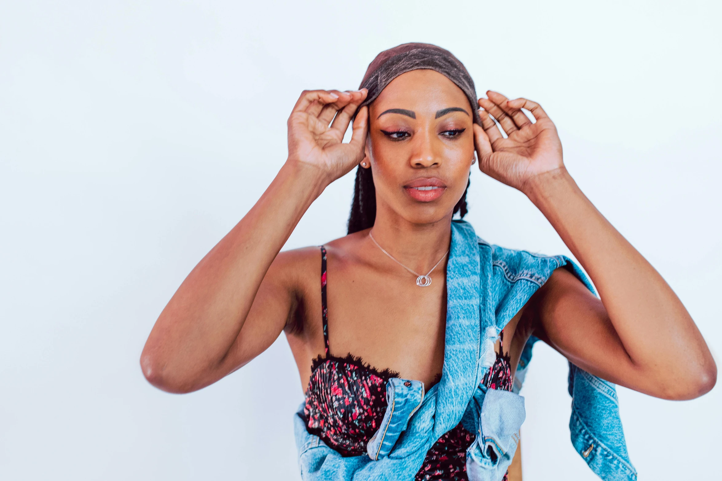 a woman holding a towel over her head, an album cover, trending on pexels, hurufiyya, rapper bling jewelry, wearing double denim, portrait mode photo, bralette