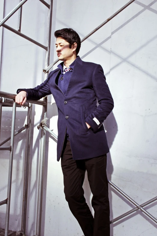 a man in a suit leaning against a railing, inspired by Tadashi Nakayama, bauhaus, wearing a purple frock coat, blue jacket, gq, profile image