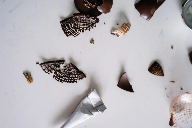 a group of chocolates sitting on top of a table, by Daniel Lieske, pexels contest winner, process art, triangle shards, pointy shell, black on white background, background image