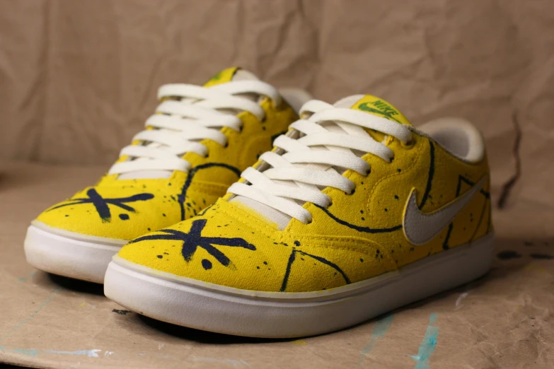 a pair of yellow sneakers sitting on top of a cardboard box, a stipple, inspired by William Yellowlees, graffiti, kickflip, hand painted textures on model, nike, kids