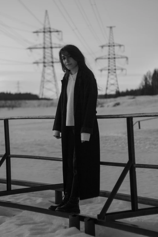 a woman standing on top of a snow covered field, a black and white photo, overlord billie eilish, low quality photo, woman in a dark factory, andrey surnov