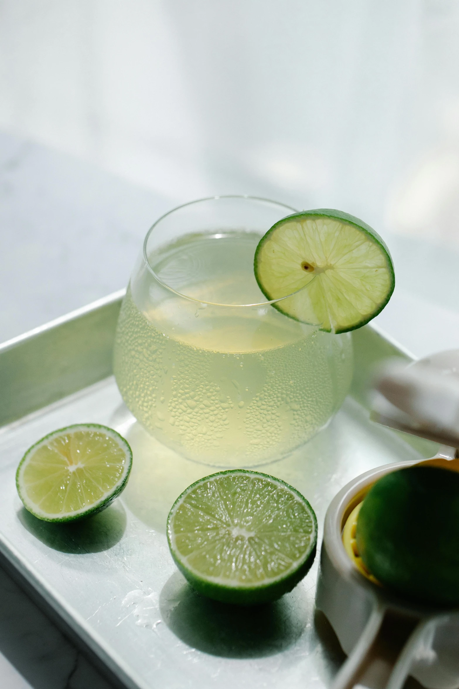 a glass of lemonade and lime slices on a tray, unsplash, photorealism, slide show, dewy skin, soup, made of glazed