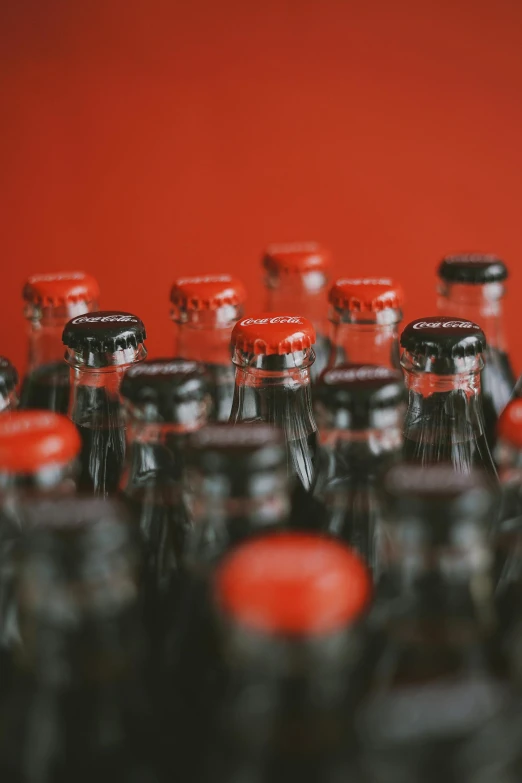 a group of glass bottles sitting on top of a table, a picture, pexels, happening, black and red scheme, soda, close together, small