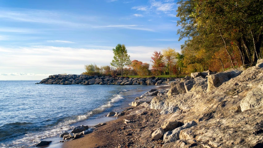 a rocky beach next to a body of water, inspired by Richmond Barthé, pexels contest winner, fall season, toronto, thumbnail, 8 k 4 k