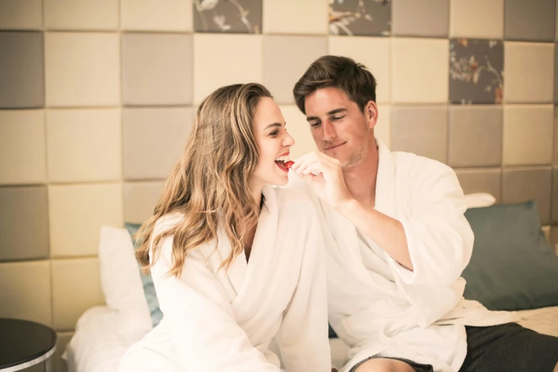 a man and a woman sitting on a bed brushing their teeth, pexels contest winner, happening, bathrobe, gorgeous lady, spa, flirting