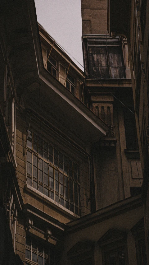 a clock that is on the side of a building, a matte painting, by Youssef Howayek, pexels contest winner, renaissance, dark and beige atmosphere, house windows, looking downwards, in an alley