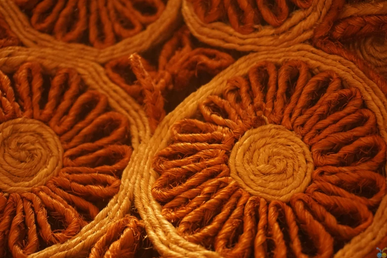 a bunch of baskets sitting on top of a table, an album cover, flickr, hurufiyya, intricate eye detail focus, orange color, made of wool, rosette