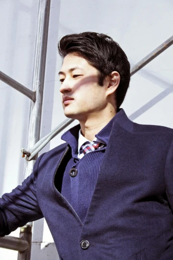 a man in a suit leaning against a wall, an album cover, inspired by Tadashi Nakayama, profile image, actor, ethnicity : japanese, wearing wool suit