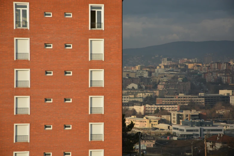 a view of a city from a high rise building, by Luis Molinari, pexels contest winner, hyperrealism, red building, le corbusier, seen from outside, ten flats