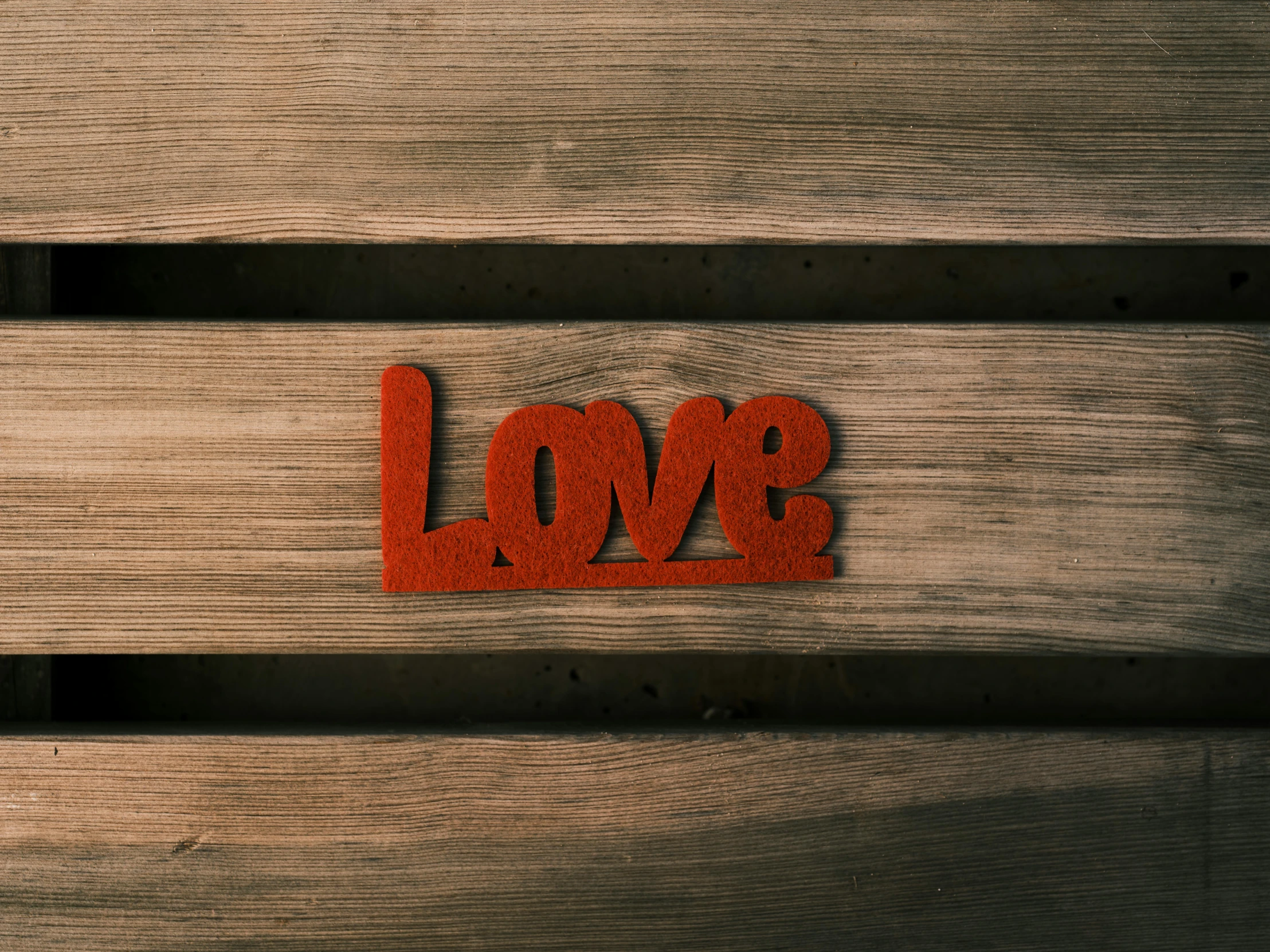 a wooden bench with the word love written on it, trending on pexels, soft red texture, album cover, felt, panel