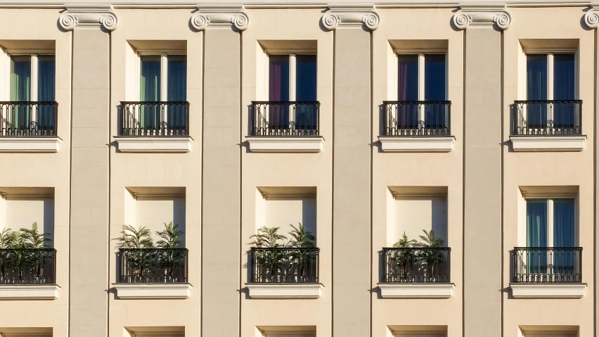 a tall building with many windows and balconies, inspired by Albert Paris Gütersloh, unsplash, neoclassicism, 3 doors, beige color scheme, multicolored, building cover with plant