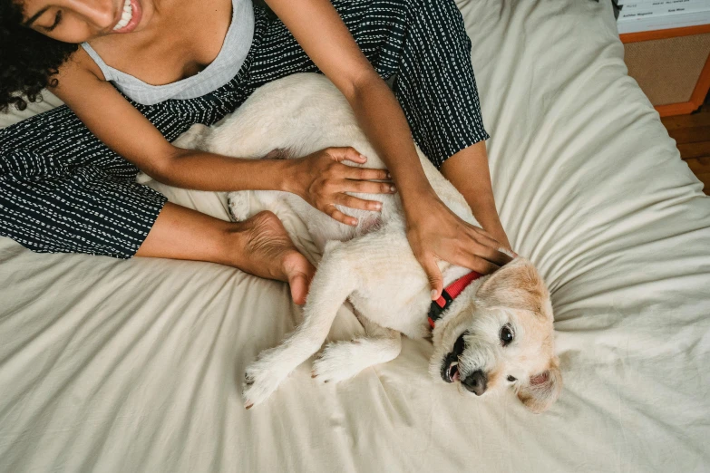 a woman laying on top of a bed with a dog, trending on pexels, renaissance, woman holding another woman, manuka, as well as scratches, black