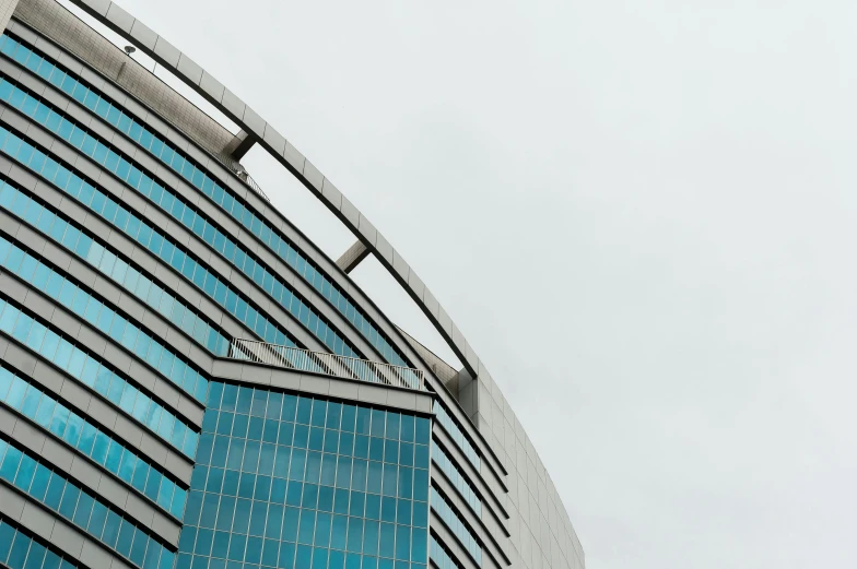 a tall building with a clock on top of it, inspired by Zaha Hadid, pexels contest winner, brutalism, beautiful futuristic new delhi, blue and grey, slight overcast weather, rounded lines