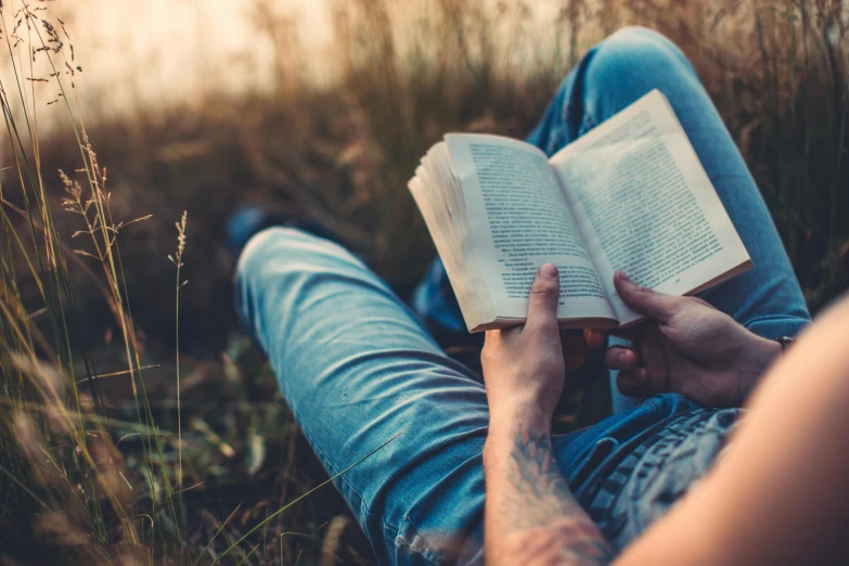 a person sitting in a field reading a book, trending on pexels, avatar image, fan favorite, full body close-up shot, realistic »