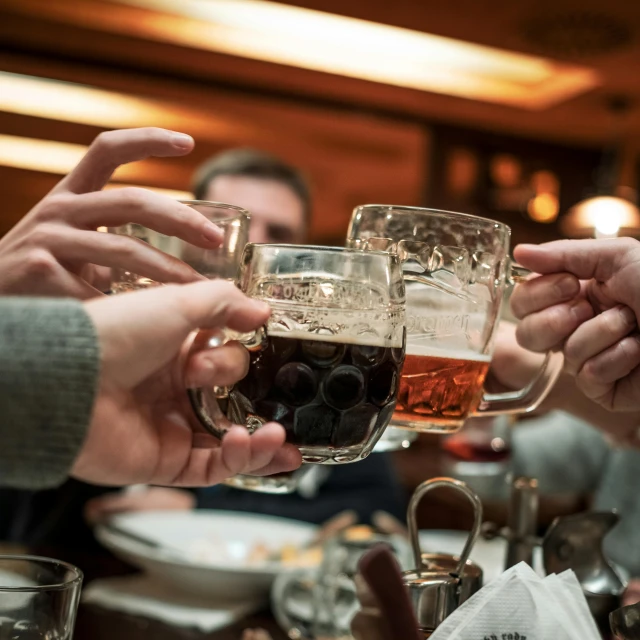 a group of people clinking glasses of beer, by Adam Marczyński, pexels, inside a tavern, winter, munich, instagram photo