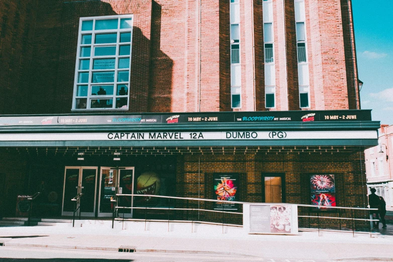 a building with a sign on the front of it, a photo, by Adam Rex, unsplash, marvel movie still, concert photo, arcade