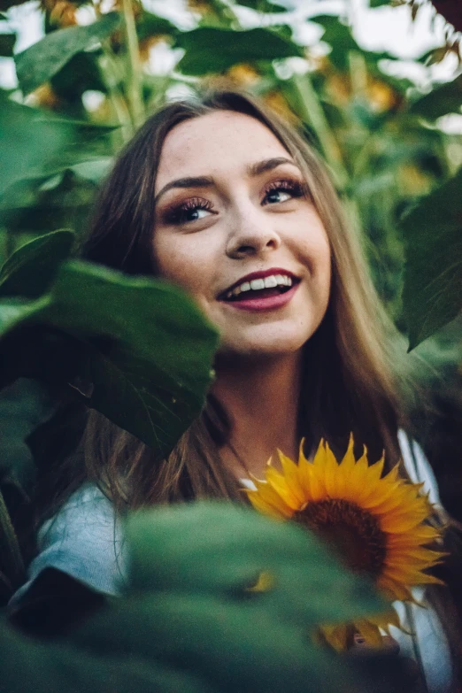 a woman smiling in a field of sunflowers, pexels contest winner, sydney sweeney, good looking face, covered in leaves, better known as amouranth