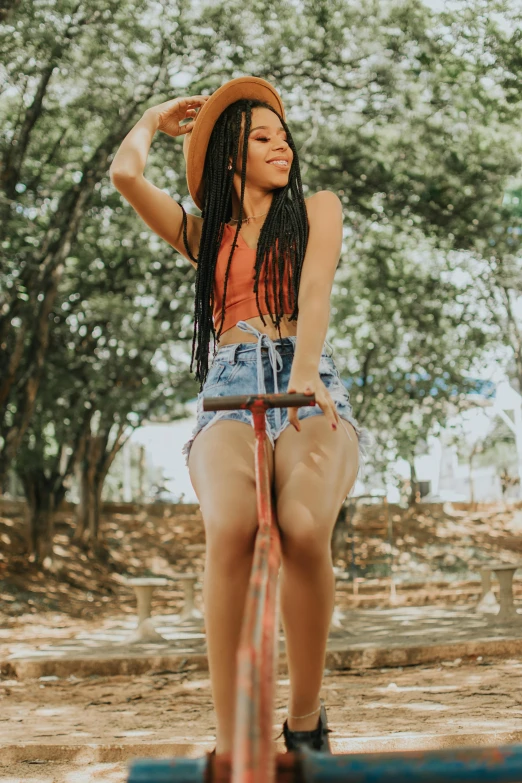 a woman riding a scooter in a wooded area, an album cover, by Lily Delissa Joseph, trending on pexels, long braids, bra and shorts streetwear, swings, satisfied pose