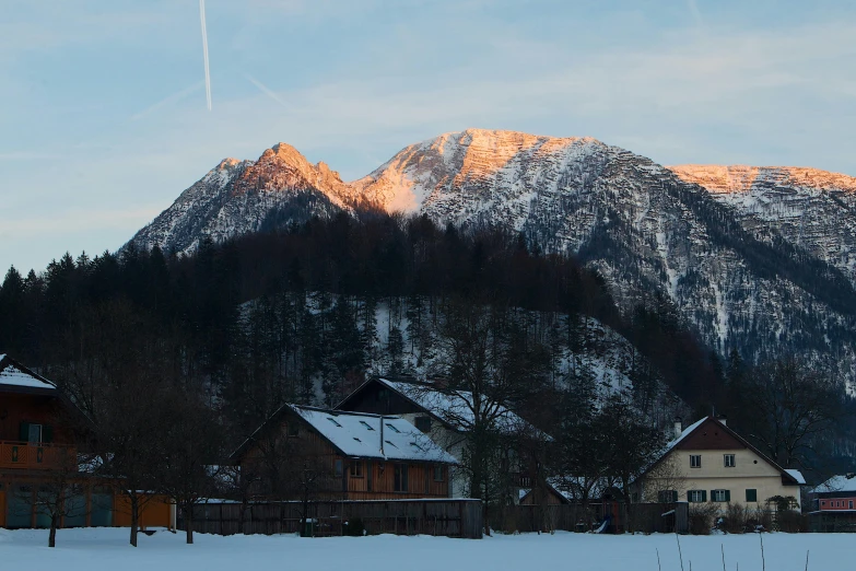 a couple of houses that are in the snow, by Sebastian Spreng, pexels contest winner, moutain in background, late afternoon sun, panoramic, 8 0 mm photo