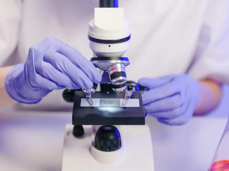 a close up of a person using a microscope, a microscopic photo, shutterstock, holography, surgical supplies, purple, medical labels, clean white lab background