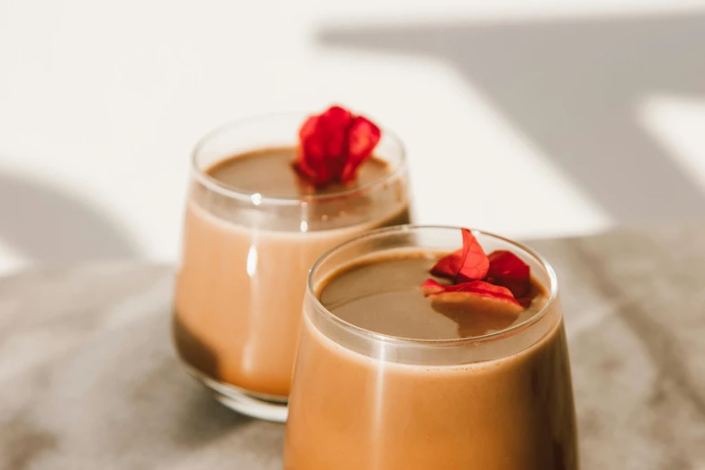 two glasses of coffee sitting on top of a table, by Julia Pishtar, trending on pexels, fully chocolate, vanilla smoothie explosion, set against a white background, background image