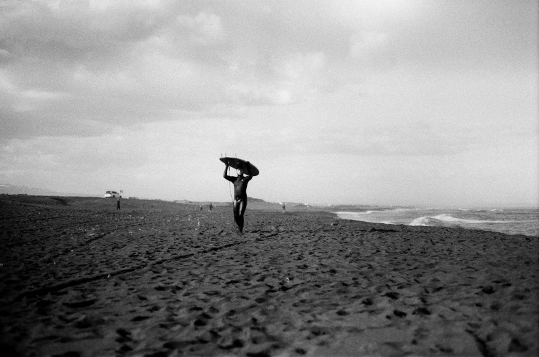 a person walking on a beach with an umbrella, a black and white photo, surfing, kano), ffffound, landscape 35mm veduta photo