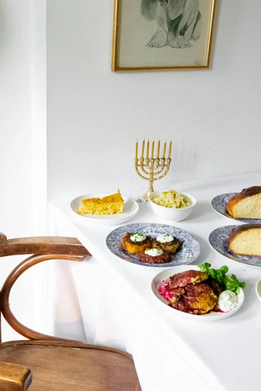 a number of plates of food on a table, by Daniel Lieske, trending on unsplash, renaissance, hebrew, white bg, gold decorations, fullbody view