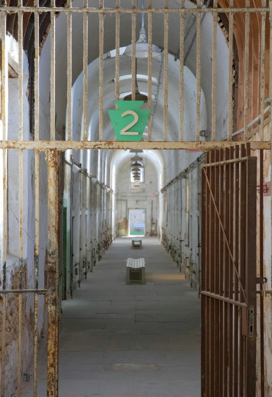 a jail cell with a number twenty on it, by Joe Stefanelli, tall arches, long hallway, preserved historical, promo image