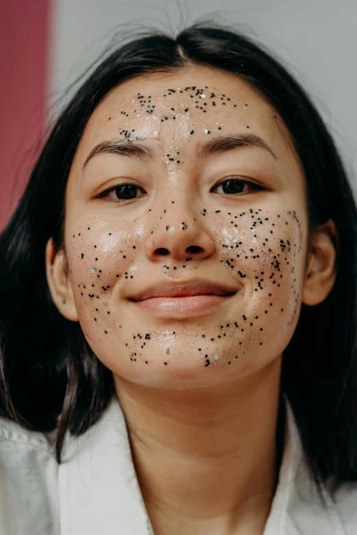 a woman with black spots on her face, trending on pexels, louise zhang, glittery, skincare, charcoal skin