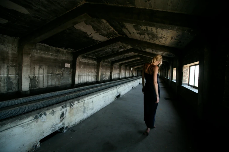 a woman in a black dress walking through a tunnel, inspired by Vanessa Beecroft, unsplash, brutalism, standing in abandoned building, standing on top of a piano, 15081959 21121991 01012000 4k, medium format. soft light