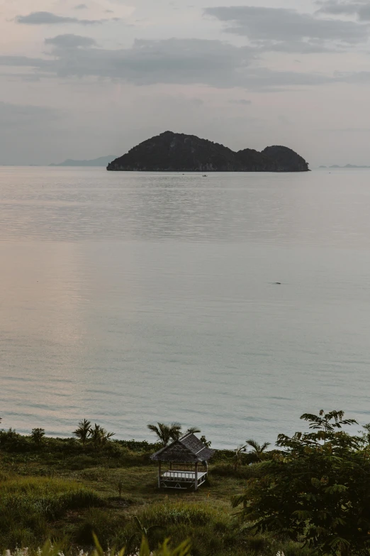 a large body of water with a small island in the distance, a picture, inspired by Elsa Bleda, unsplash, sumatraism, views to the ocean, vietnam, late summer evening, sparsely populated