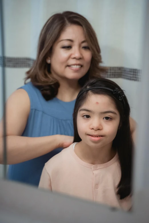 a woman combing a young girl's hair in front of a mirror, by Elaine Duillo, slide show, marfan syndrome, cindy avelino, in bathroom