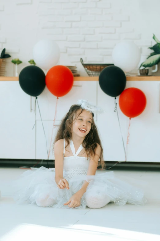 a little girl sitting on the floor in front of a bunch of balloons, red white and black color scheme, on a white table, wearing a white dress, profile image