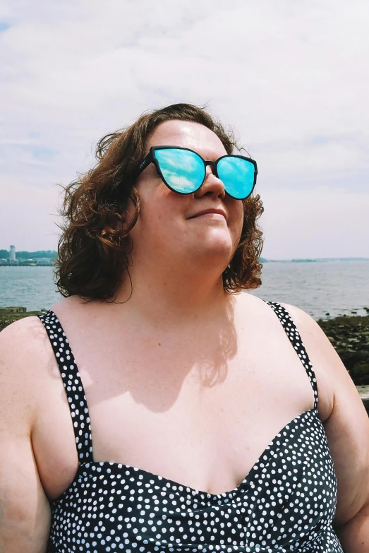 a woman standing in front of a body of water, wearing blue sunglasses, bbwchan, subreddit / r / whale, freckles