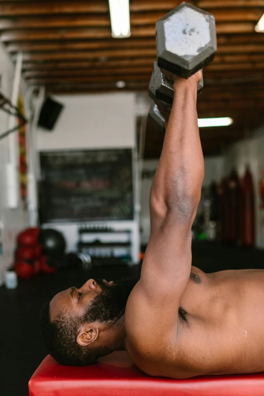 a man laying on top of a red bench holding a dumbble, thrusters, jemal shabazz, gif, press photos