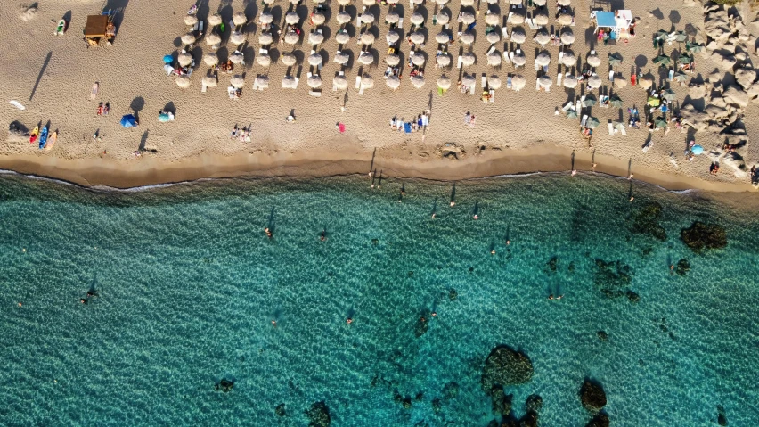 a beach filled with lots of umbrellas next to the ocean, by Carlo Martini, pexels contest winner, greece, aerial illustration, 🦩🪐🐞👩🏻🦳, slim aarons