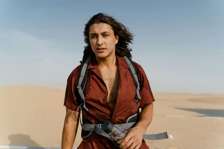 a man standing in the middle of a desert, trending on pexels, renaissance, he looks like tye sheridan, carrying survival gear, avan jogia angel, in the desert beside the gulf