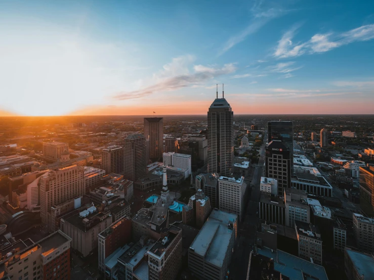 an aerial view of a city at sunset, by Lee Loughridge, unsplash contest winner, happening, midwest town, tourist photo, skyline showing, historical photo