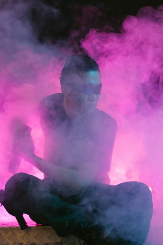 a man sitting in the middle of a cloud of smoke, pink lighting, grace jones, taken in the late 2010s, bad bunny