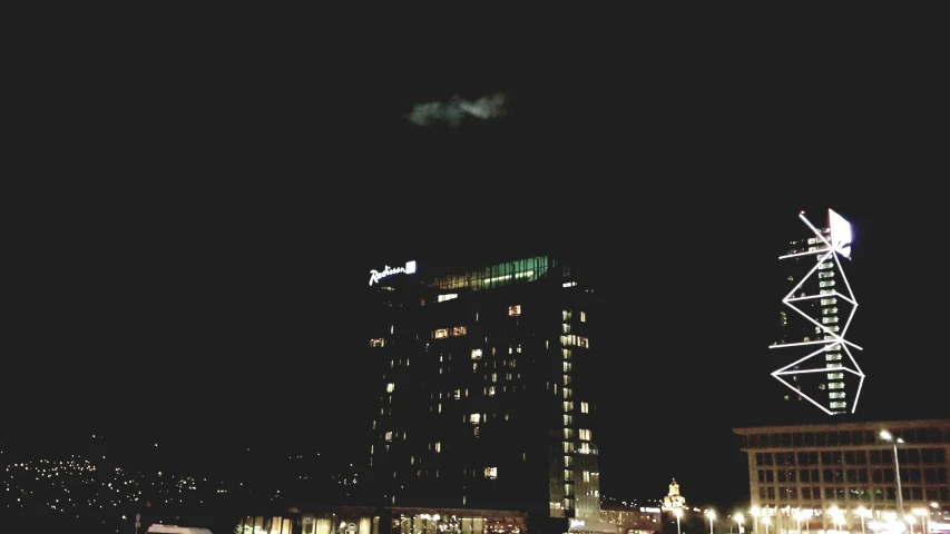 a plane flying over a city at night, a screenshot, by Andrei Kolkoutine, unsplash, realism, apartment building on the moon, helsinki, hotel room, gloomy lighting!!!