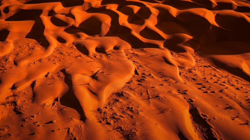 a group of footprints in the sand of a desert, by Lee Loughridge, pexels contest winner, land art, orange glow, curved lines, dessert, a brightly coloured