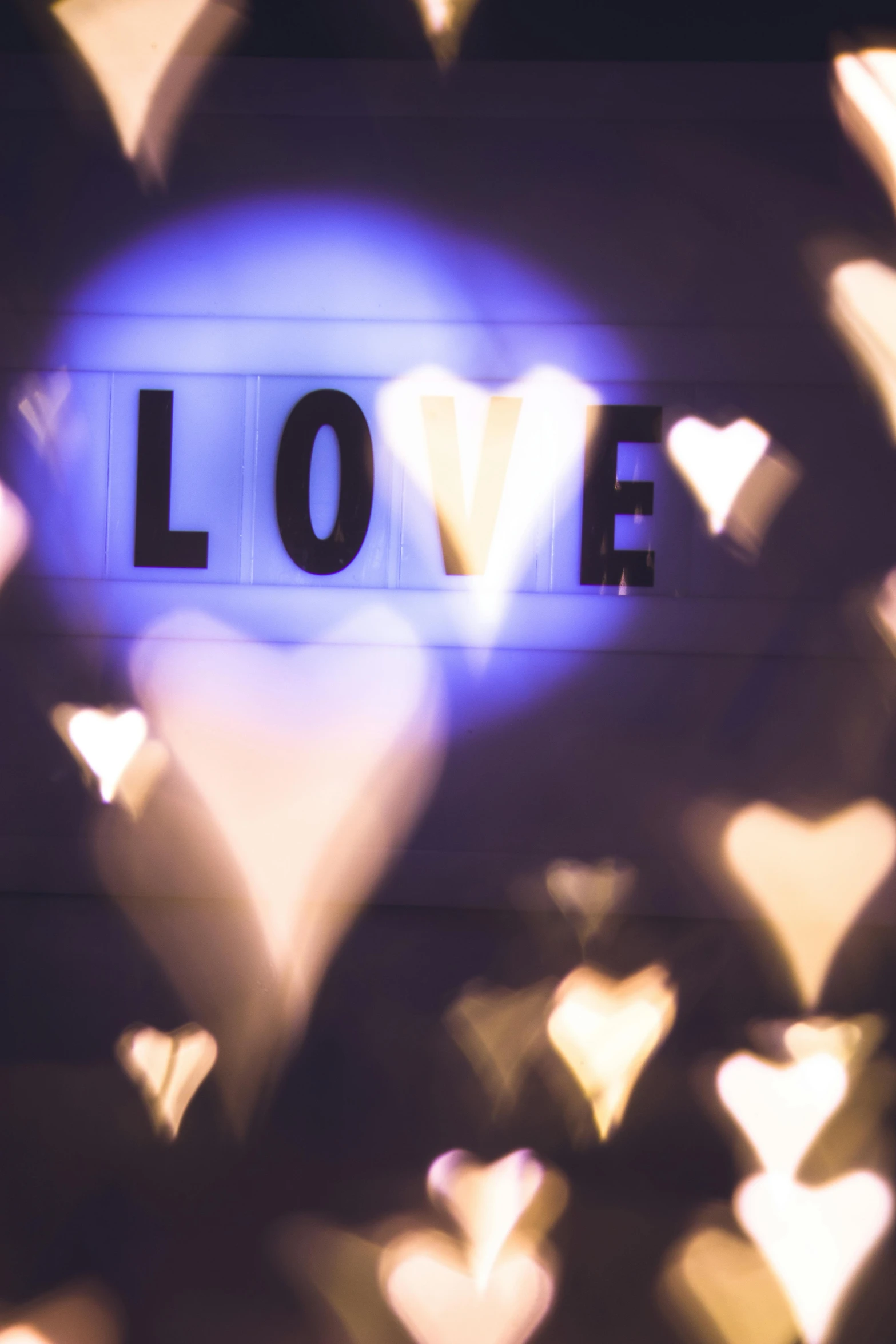 a blurry picture of a heart with the word love in it, pexels, lightshow, several hearts, indoor picture, kind